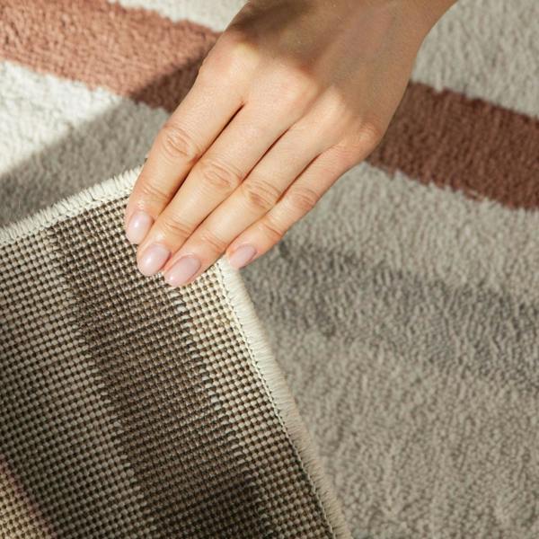 Hand touching a textured fabric surface with a neutral color palette
