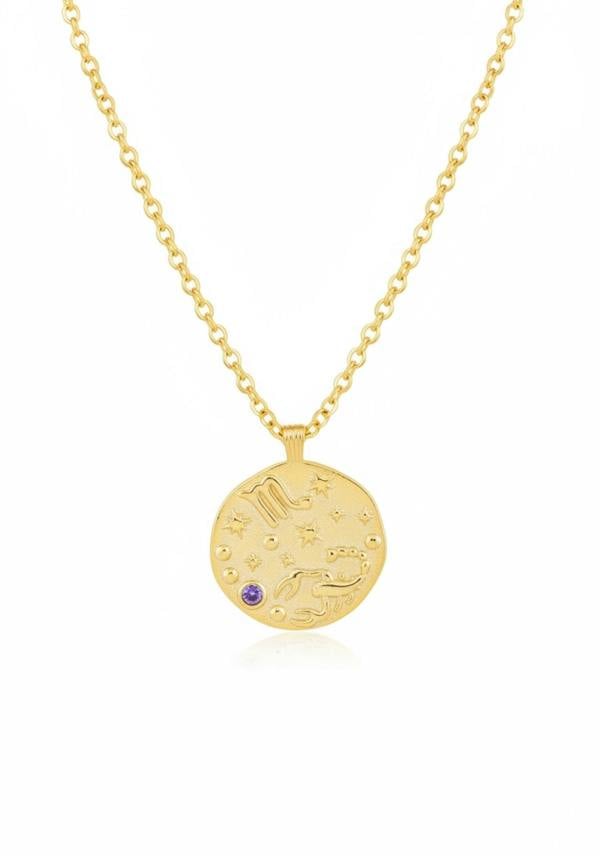 Gold necklace with a round pendant featuring celestial designs on a white background