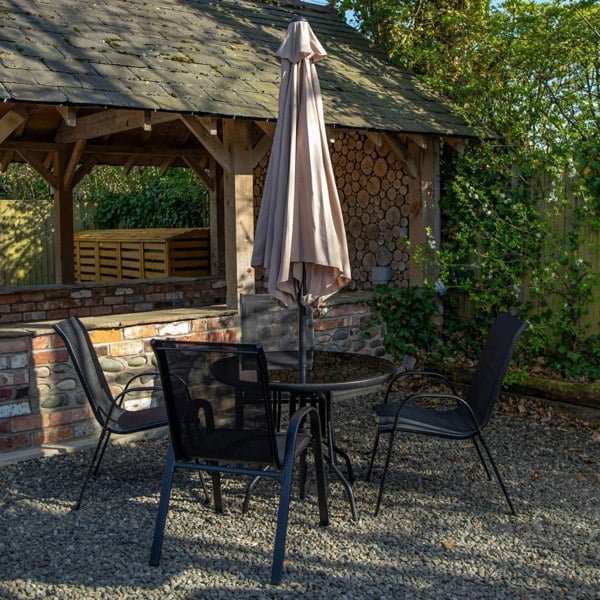 Samuel Alexander Outdoor 4 Person Round Glass Top Garden Dining Table Chairs With Beige Parasol and Base Set