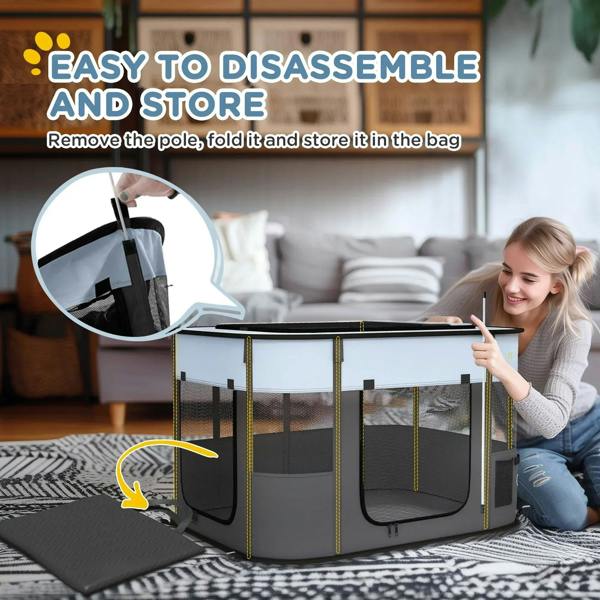Grey foldable dog pen on floor with mesh sides and side door, storage bag shown