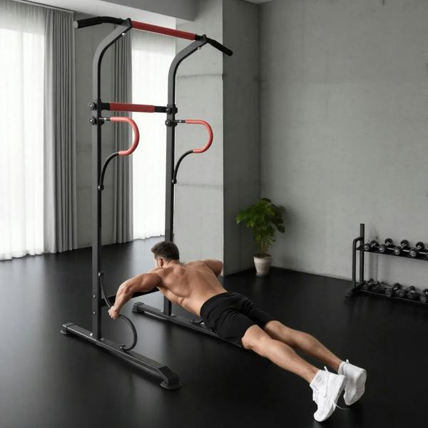 Power tower pull-up station in use: man performing push-ups with black frame and red grips