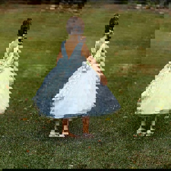Girl standing on grass in silver uk flower girl dress