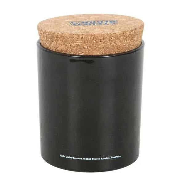 Black scented candle jar with cork lid; base text visible.