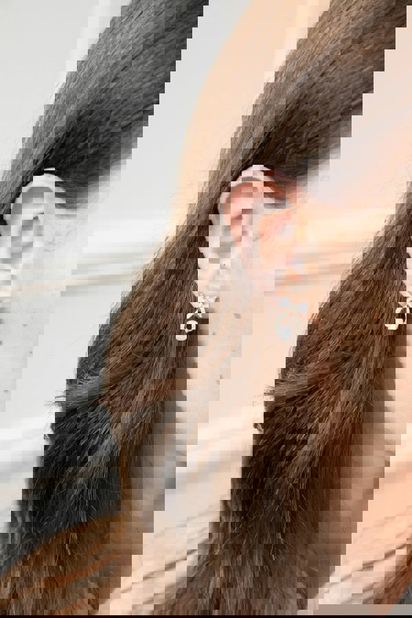 SVNX Studded Bow Earrings with Hanging Pearl in Gold Colour