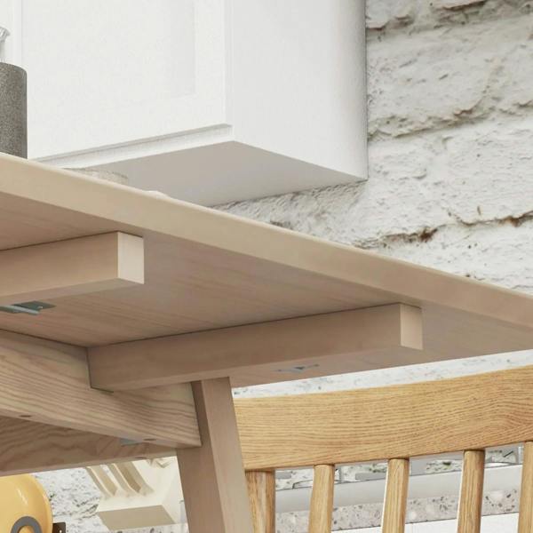 Natural wood drop-leaf table underside showing support and hinge detail