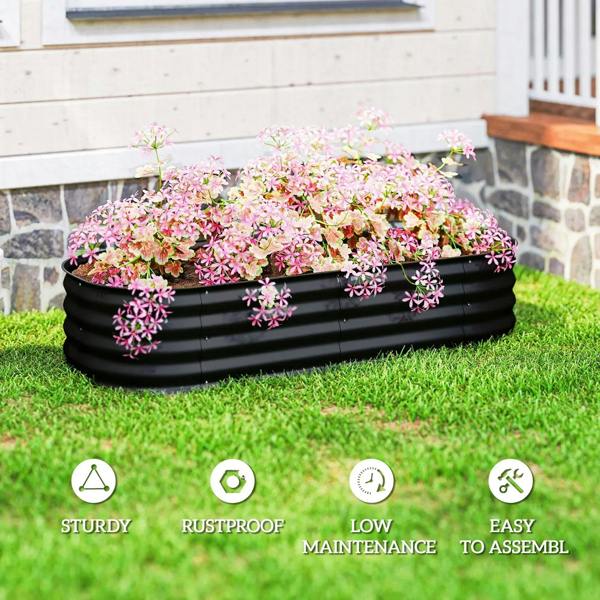 Black raised garden bed metal planter box with pink flowers on green grass