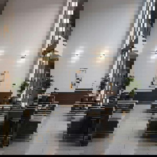 Black internal wall light in a hotel lounge two lights on the far end wall and sofas and tables in the picture