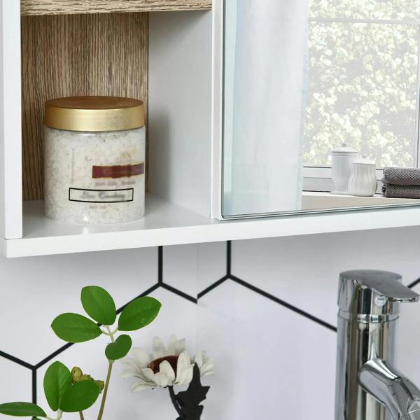 White cabinet interior shelf holding a jar and bathroom items beside a reflective mirror panel