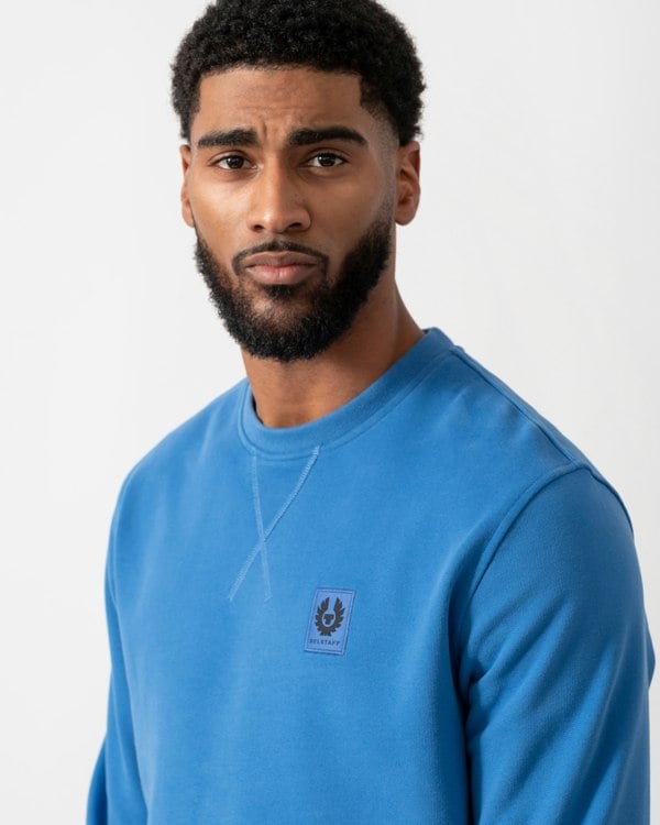 close up of a model wearing Belstaff Mens Crew Neck Sweatshirt With Logo Patch in Marine Blue