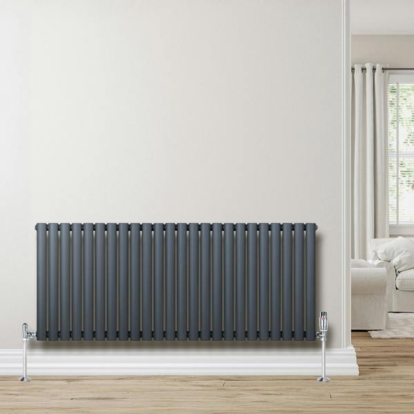 Oval single column radiator in anthracite grey, featuring sleek vertical lines and chrome valves, mounted on a light wall
