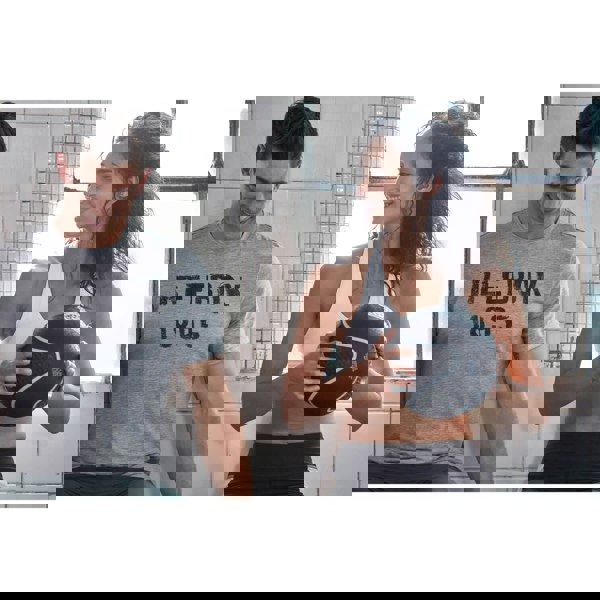 Man wearing a Reebok shirt and woman holding a 5kg medicine ball in a gym setting