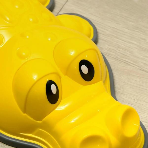 Yellow crocodile-shaped stepping stone with a smiling cartoon face