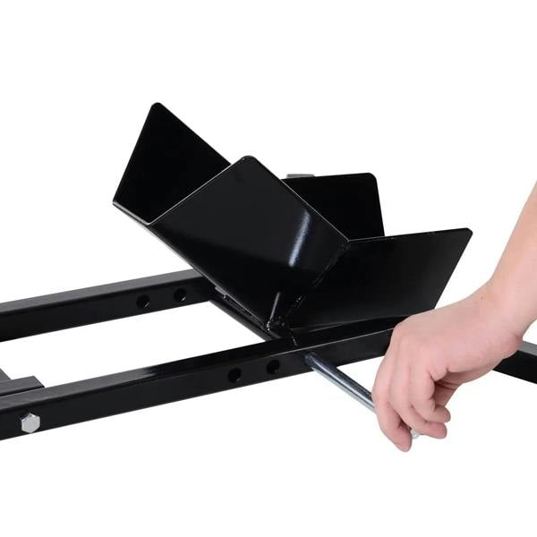 Hand adjusting black motorcycle wheel chock cradle on adjustable metal rails