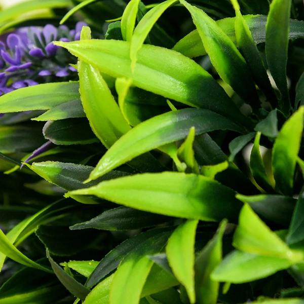 Close-up of artificial green leaves with small purple flower highlights