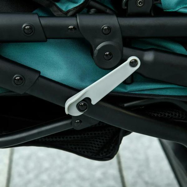 Pet stroller jogger folding mechanism close-up with black frame and green fabric