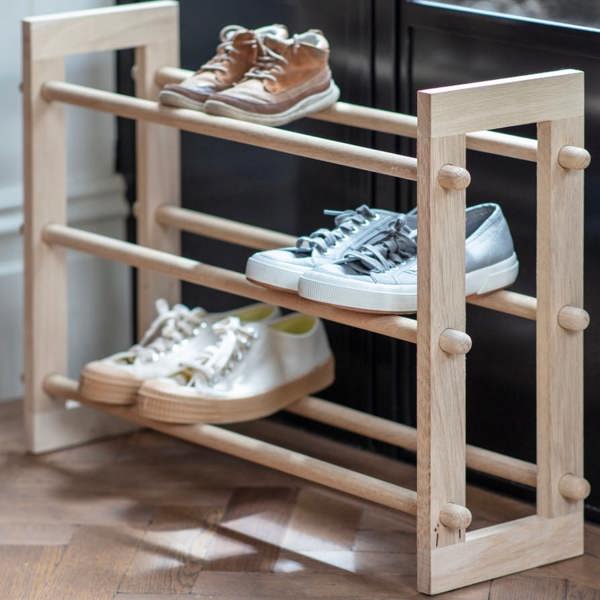 A 3-tier natural oak shoe rack displaying various pairs of shoes on a parquet floor by Abode Home & Gifts.