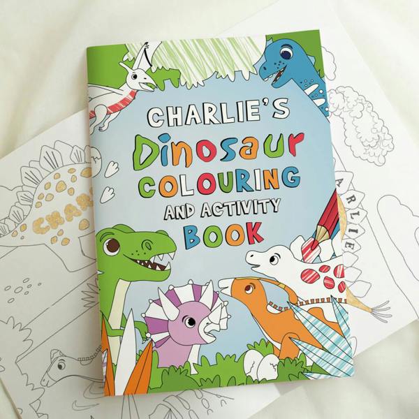 Opened Personalised Dinosaur Colouring and Activity Book showing the colourful front cover with the name "CHARLIE'S" printed at the top.