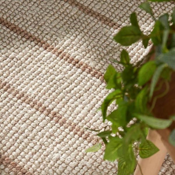 Textured beige rug with vertical stripes on a white background