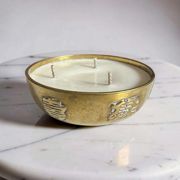 Decorative candle in a gold holder on a marble surface