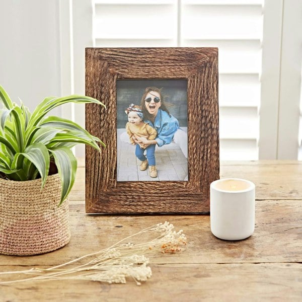 Natural Mango Wood Photo Frames with flowers on a shelf.