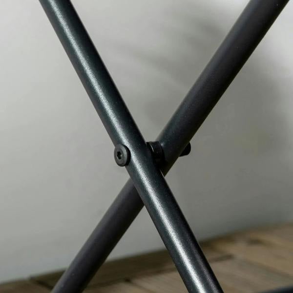 Close-up of black metal X-frame joint for a square folding wicker table