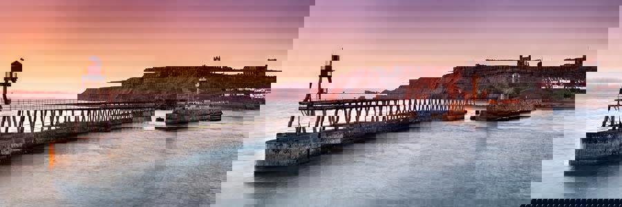 sunrise over whitby coastline