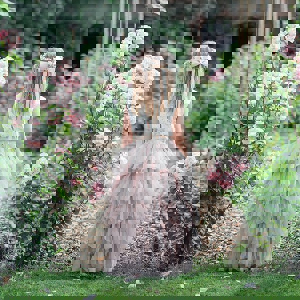 Young girl in wedding gardens wearing flower girl dress