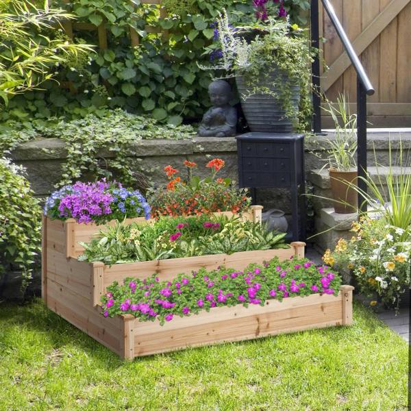 Three-tier raised wooden garden planter bed with flowers in a backyard garden