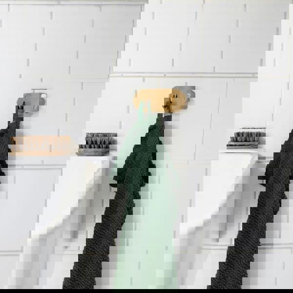 Brushed brass double towel hook on bathroom wall