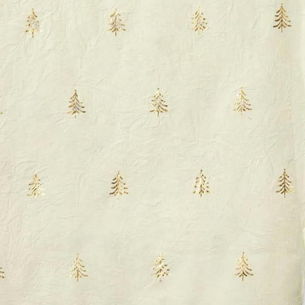Close-up texture of warm white handmade recycled cotton wrapping paper featuring a repeating gold foil Christmas tree motif.