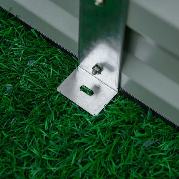 Metal raised garden bed planter box corner with drainage cover plate on grass