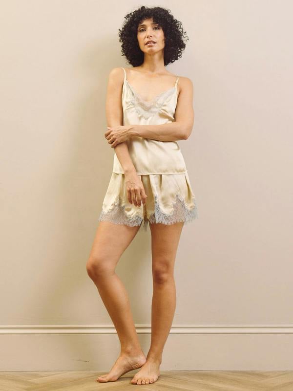 Woman wearing a light-colored lace nightgown against a plain background