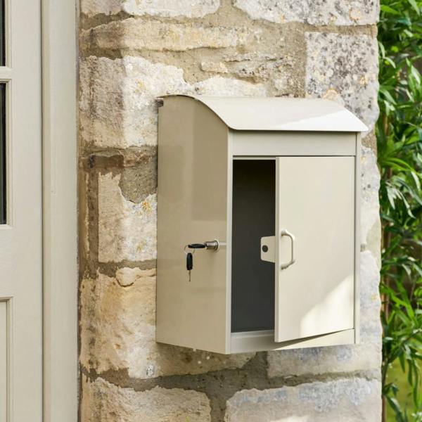 The front door of the clay parcel box open with keys in the lock, showing the secure interior.