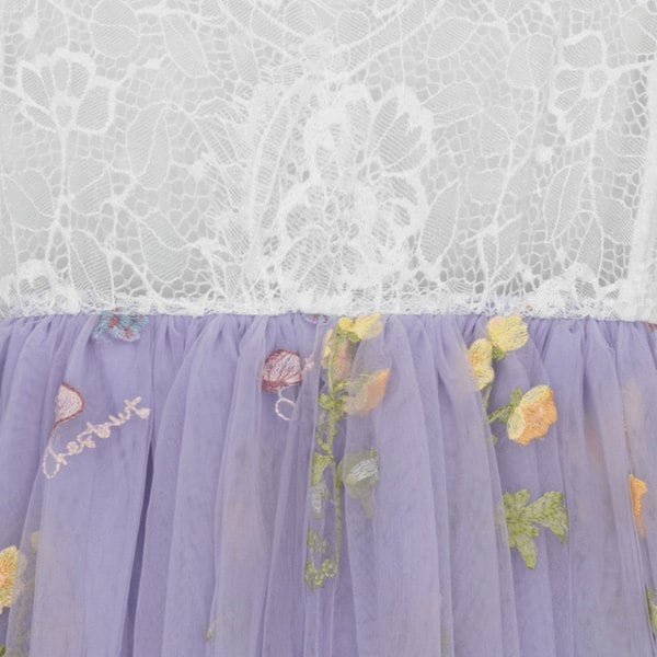 Lace top and purple tulle skirt with floral embroidery on a white lace background