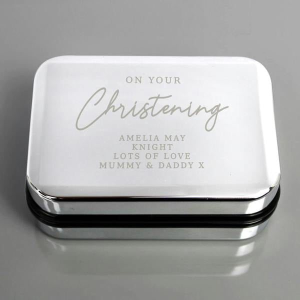 A top-down shot of a rectangular, highly polished silver-plated trinket box engraved with 'ON YOUR Christening' in mixed fonts, followed by uppercase text reading 'AMELIA MAY KNIGHT LOTS OF LOVE MUMMY & DADDY X'.