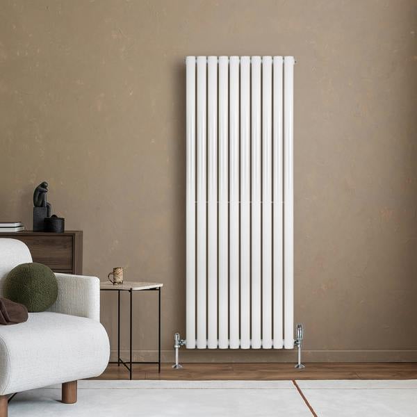 Sleek white oval single column radiator with vertical bars, mounted on a textured wall, enhancing modern interior decor