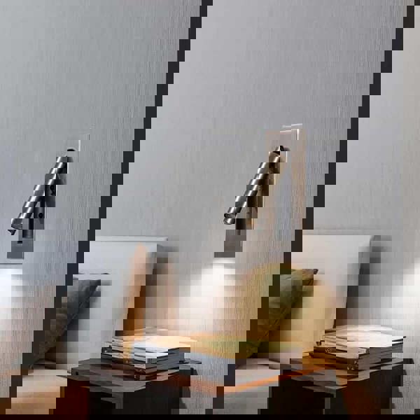 brushed copper recessed bedroom reading light mounted on the wall next to a bed over a bedside table 