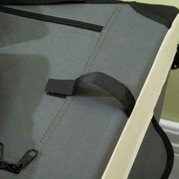 Close-up of grey cushioned base with black handle and stitched trim inside carrier