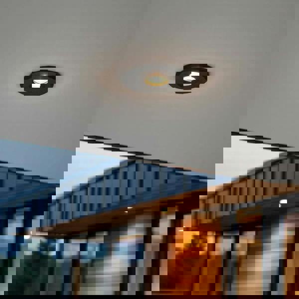 black small outdoor downlight mounted under the soffit of a modern home