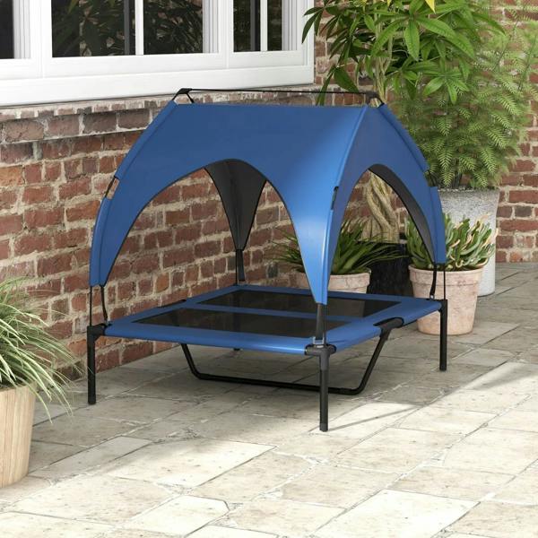 Dark blue elevated dog bed with arched canopy and breathable mesh platform outdoors