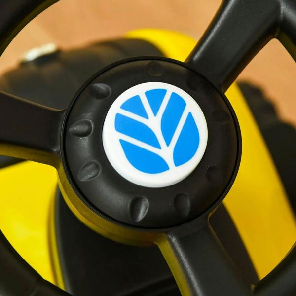 Black steering wheel with blue emblem center on yellow ride-on tractor walker