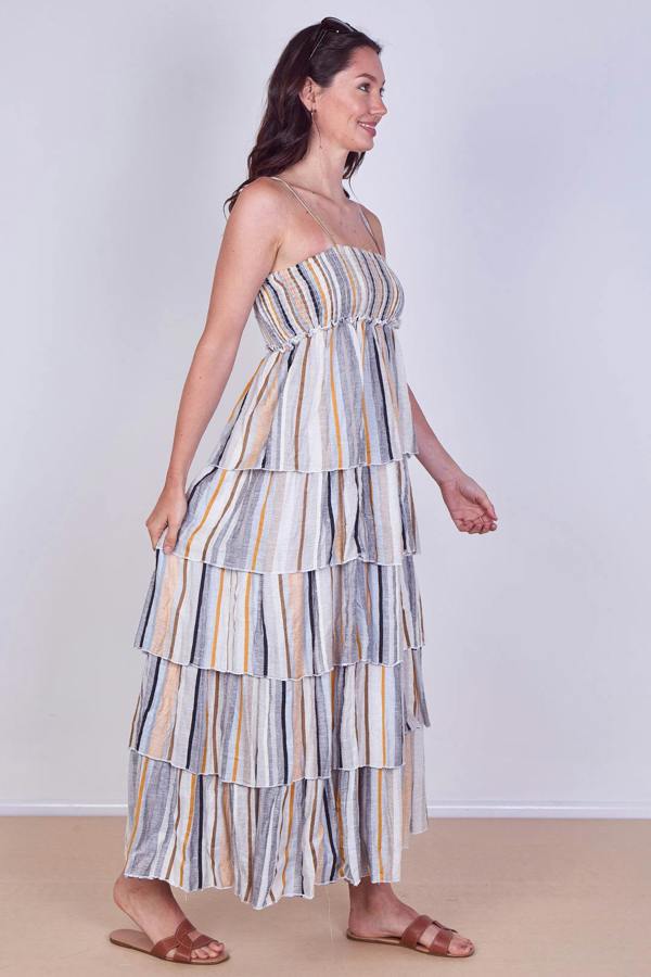 Woman wearing a striped tiered dress on a plain background