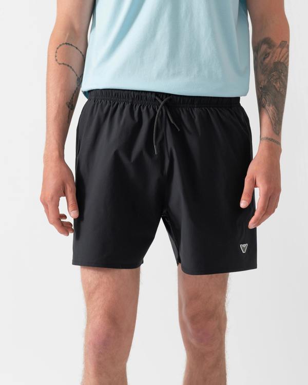 model wearing a pai of Emporio Armani Mens Swim Shorts with Eagle Logo in Black