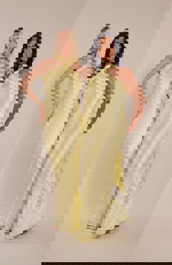 2 models wearing halterneck satin bridesmaids dress in a shade of lemon butter yellow.