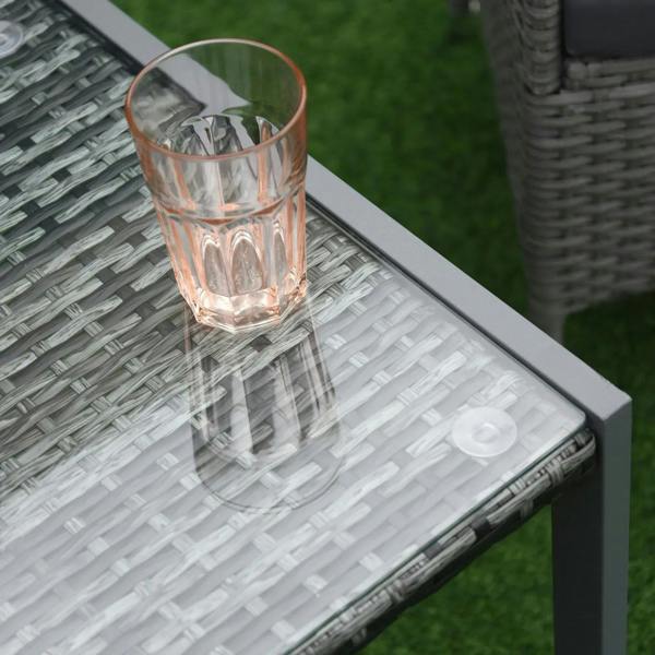 Dark glass tabletop with grey rattan weave, featuring a copper glass cup