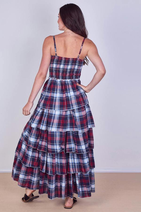 Woman wearing a plaid dress with a plain background