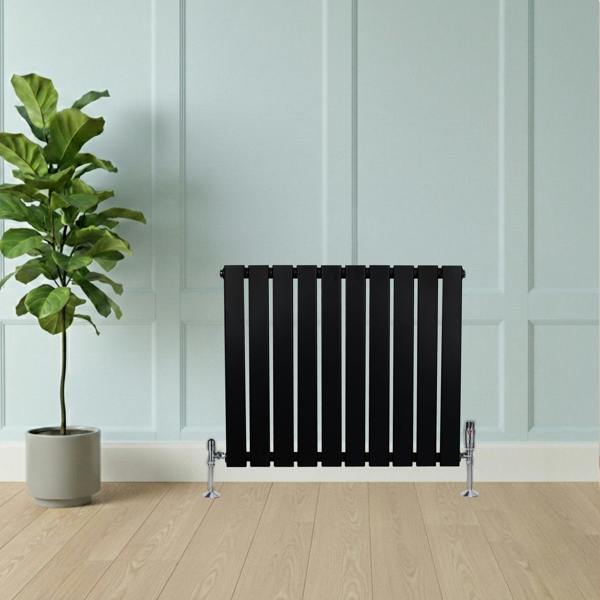 Flat black single column radiator, 600 x 700mm, featuring sleek vertical slats, positioned against a light blue wall with a plant nearby