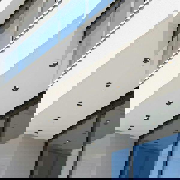 black small outdoor downlight mounted under roof of a modern home 