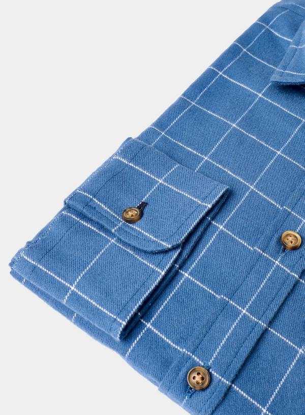 Folded blue checkered shirt with brown buttons on a light gray background