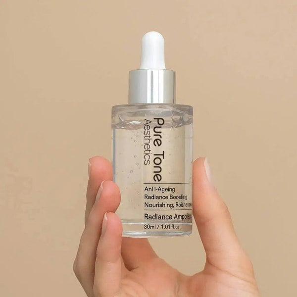 Hand holding a Pure Tone Skincare dropper bottle against a beige background